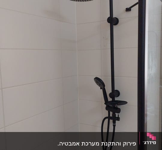 ראש מקלחת שחור עם צינור במקלחת לבנה